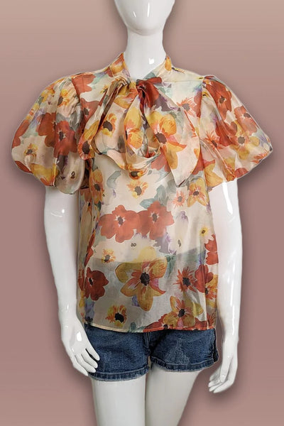 Orange print ruffled short sleeve top.  Bow.