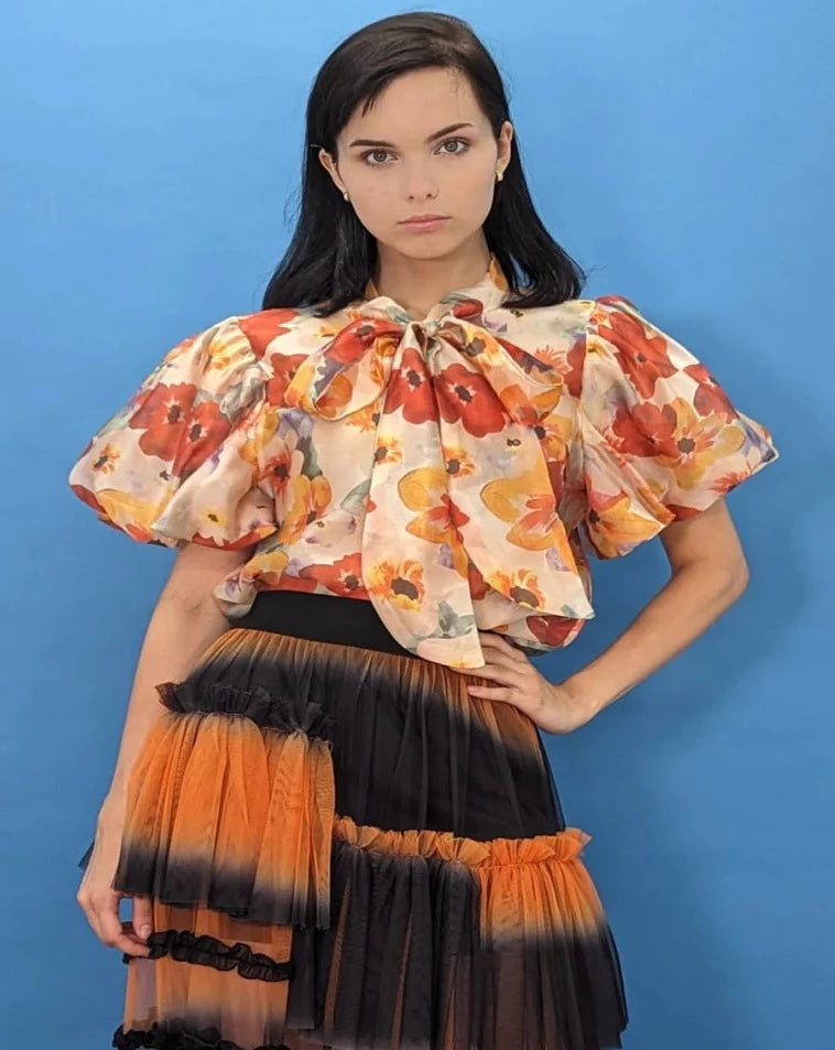 Orange print ruffled short sleeve top.  Bow.